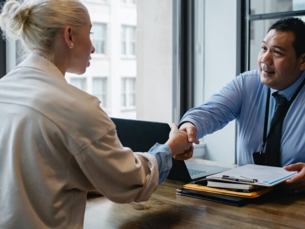 ethnic businessman shaking hand of applicant in office