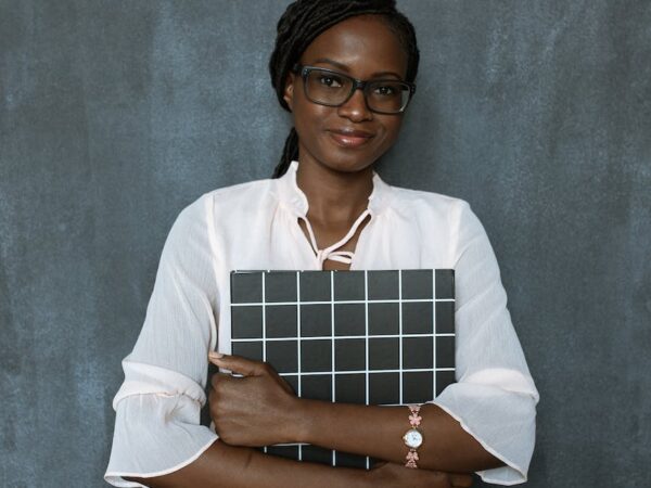 woman in white dress shirt holding brown and white paper