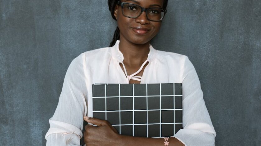 woman in white dress shirt holding brown and white paper