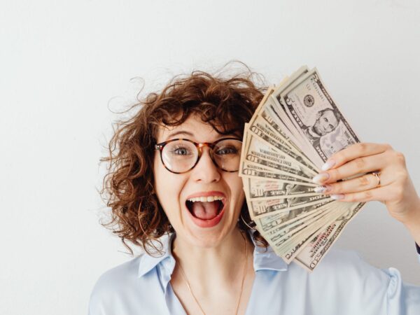 happy woman in blue long sleeve blouse holding money